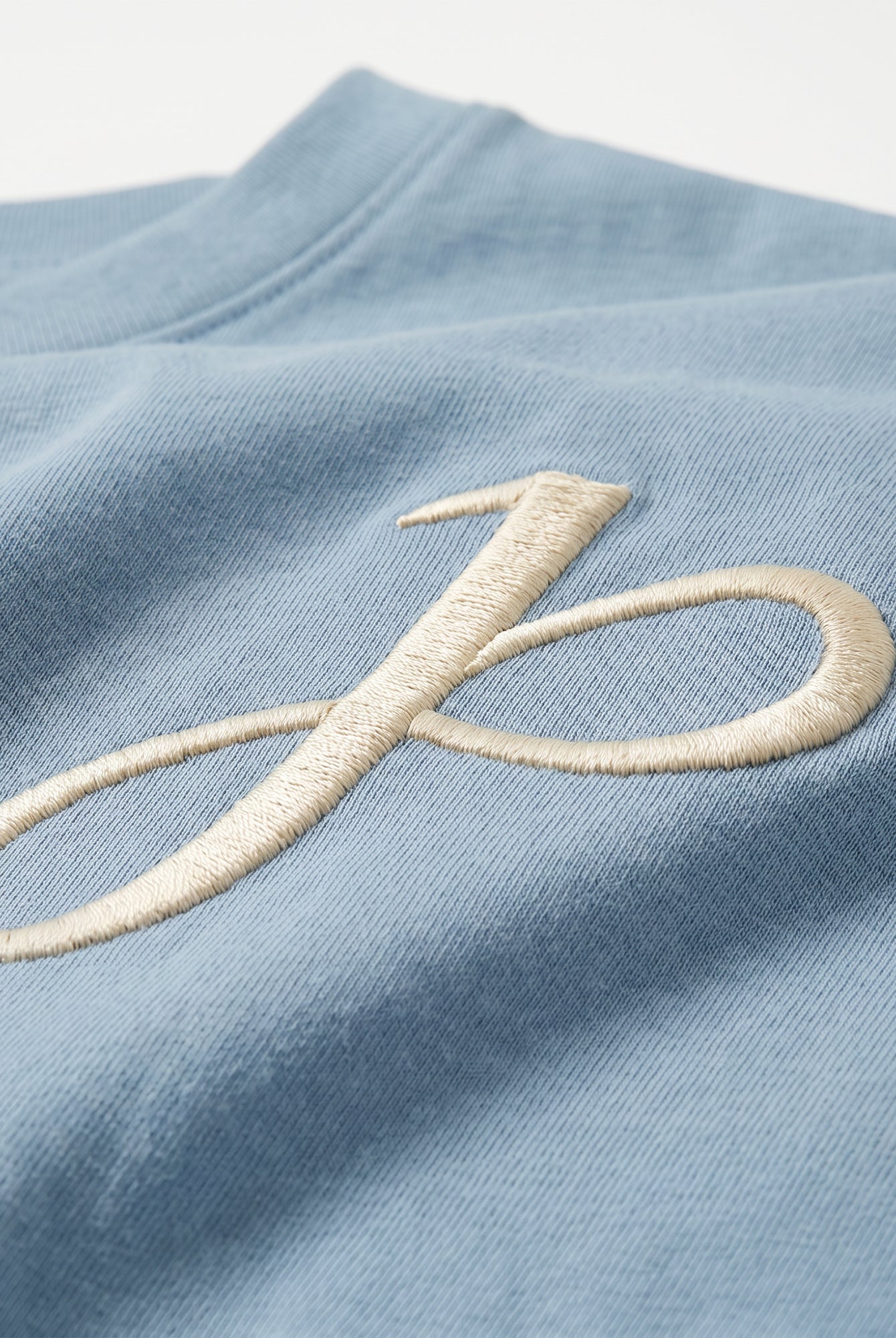 Babyblaues T Shirt mit J Monogramm und Schriftzug am Kragen
