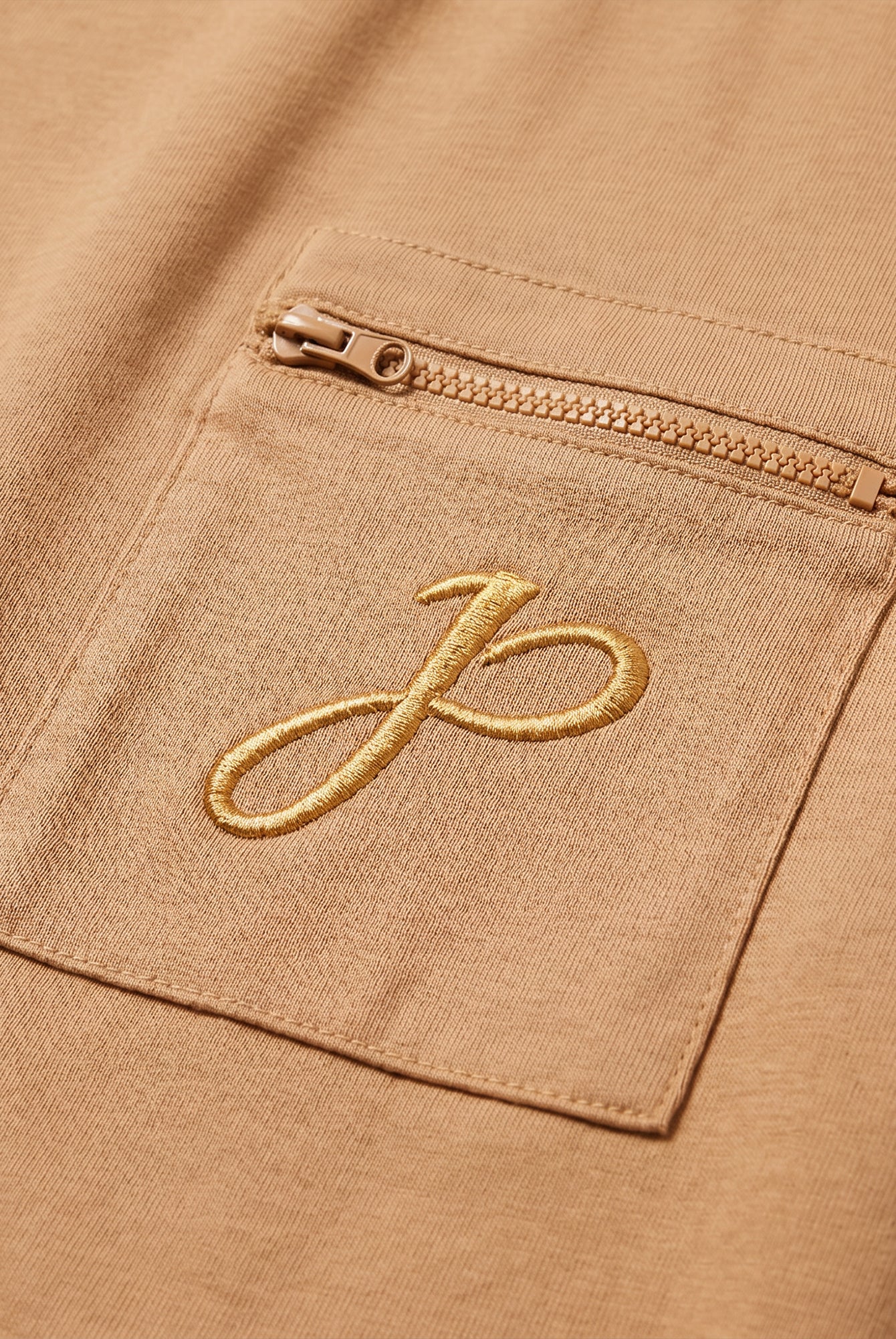 Beiges T Shirt mit Brusttasche, Reißverschluss und J Monogramm