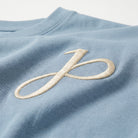 Babyblaues T Shirt mit J Monogramm und Schriftzug am Kragen